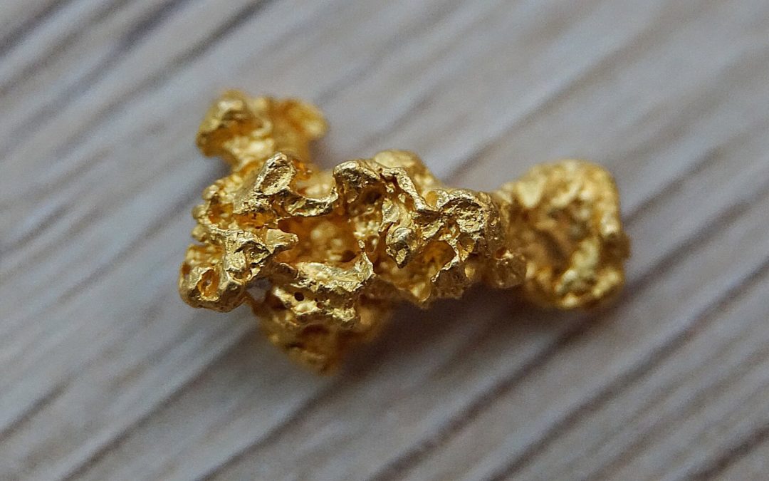 A small gold nugget on a textured table